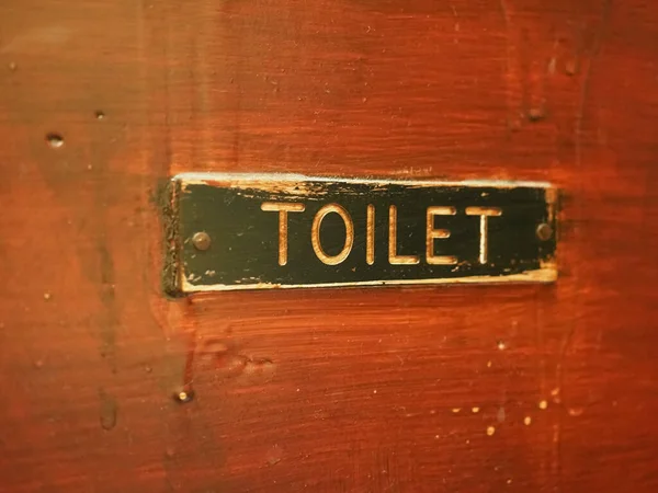 木门上的旧厕所标志 — 图库照片