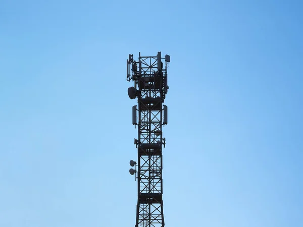 コピースペースのある青い空の上のセルラーネットワークの一部であるセルラーアンテナタワーと電子無線トランシーバ装置 — ストック写真