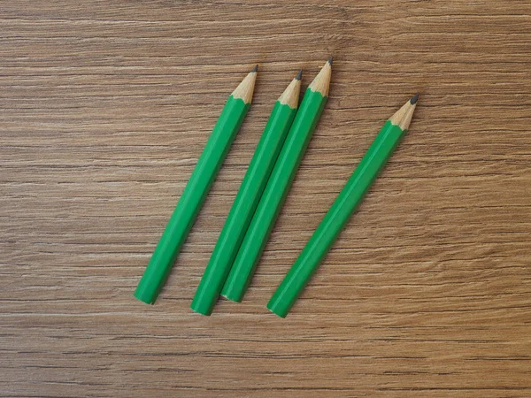 Τέσσερα Πράσινα Μολύβια Ξύλινη Επιφάνεια Εργασίας — Φωτογραφία Αρχείου