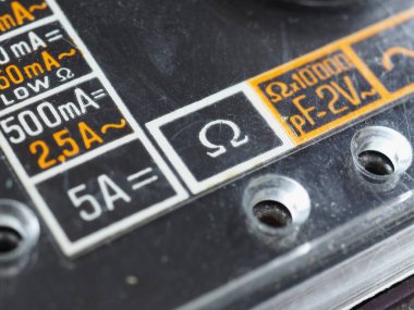 Eski bir analog çoklu ölçüm aletinde elektrik sembolleri
