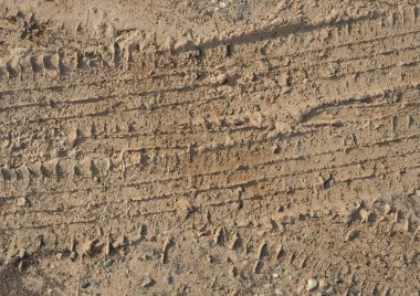 tyre footprint in brown earth soil useful as a background