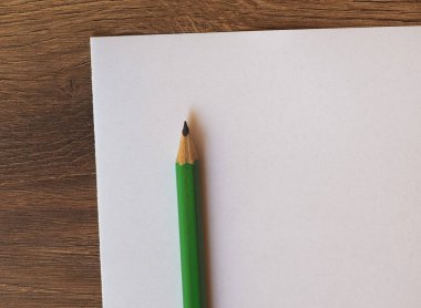 boş kağıt üzerinde yeşil kalem sayfa üzerinde ahşap masaüstü kopya alanı ile