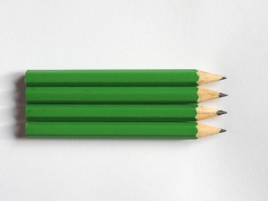 Boş kağıt üzerinde dört yeşil kalem ve kopyalama alanı