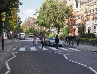 LONDON, UK - CIRCA OCTOBER 2022: People crossing Abbey Road zebra crossing made famous by the 1969 Beatles album cover