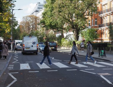 LONDON, UK - CIRCA OCTOBER 2022: People crossing Abbey Road zebra crossing made famous by the 1969 Beatles album cover