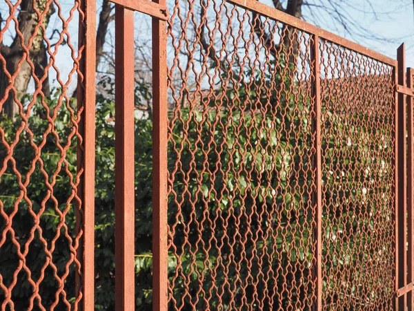 Красный Металл Забор Зеленом Фоне Листьев — стоковое фото