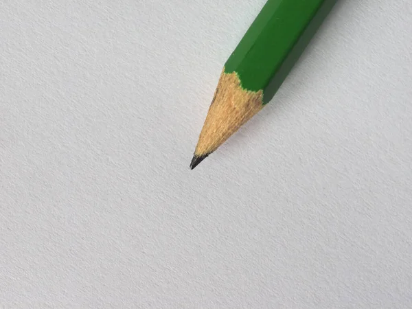木制桌面上空白纸片上的绿色铅笔 有复制空间 — 图库照片