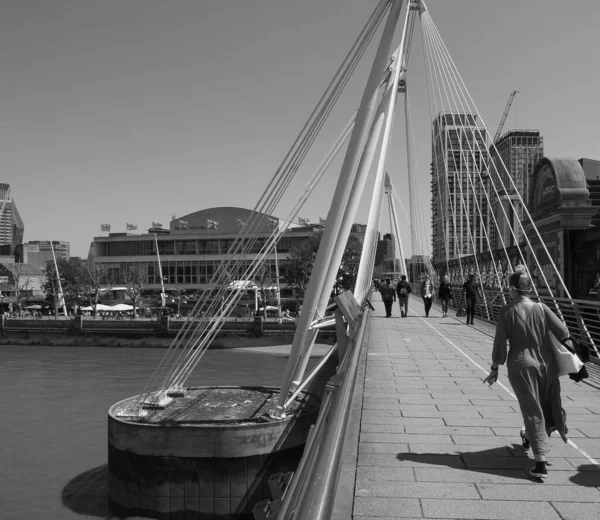 ロンドン 2023年6月8日 テムズ川を渡ってゴールデン ジュビリー橋を渡る人々は 黒と白でサウスバンクとウォータールーへの充電クロスをリンクします — ストック写真