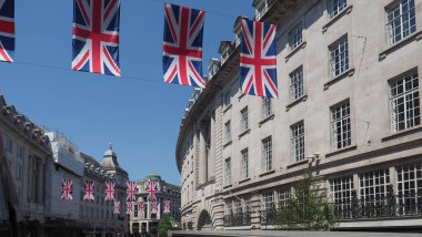 LONDON, İngiltere - 7 Haziran 2023: 6 Mayıs 2023 tarihinde Kral Charles III 'ün taç giyme töreni için Regent Caddesi' nde Union Jack bayrakları