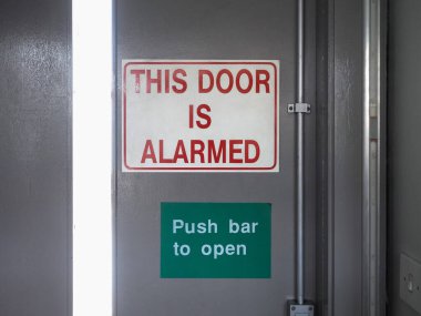 Bu kapı alarmlıdır. Acil çıkış işaretini açmak için düğmeye basın.