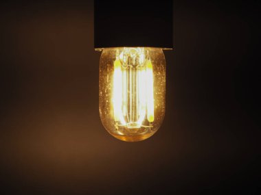 Koyu arkaplan üzerinde parlak LED filament ampul