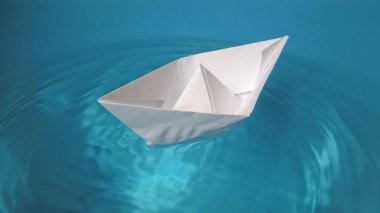 Mavi sularda yüzen oyuncak kağıt tekne