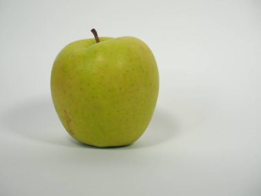 Açık gri arka planda altın gibi lezzetli yeşil elma