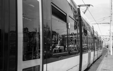 Tramvay tramvayı siyah beyaz durakta duruyor.