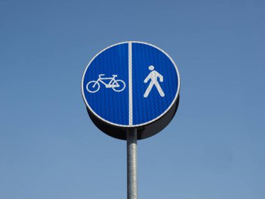 Mavi gökyüzünde bisiklet yolu ve yaya yolu tabelası