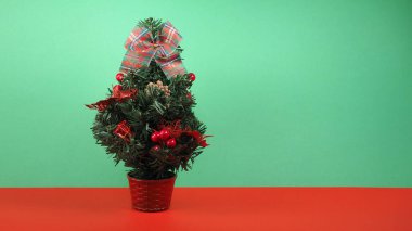 Yeşil ve kırmızı arkaplanda fotokopi alanı olan noel ağacı