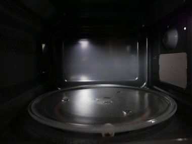 Koyu gri mikrodalga fırının içi kurşun ışıkla kaplı.