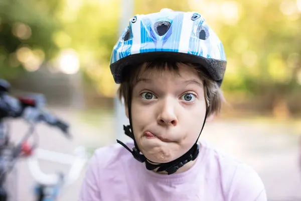 Young Boy Helmet Making Faces Outdoors Stock Photo