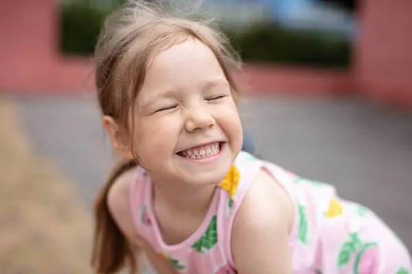 かわいい女の子は笑って 屋外で顔を作る ロイヤリティフリーのストック写真