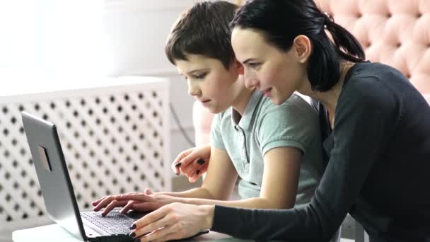 母亲和儿子都在网上学习 坐在笔记本电脑上 并在笔记本上记笔记 高质量的录像 — 图库视频影像