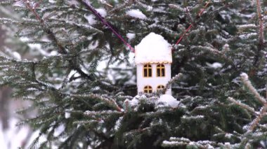 Bird feeder hanging from a tree. Red birdhouse with sparrow during winter in snow.