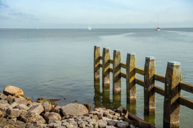Yelkenli yatlar ve balıkçı tekneleri limana demirlemiş. Hollanda.
