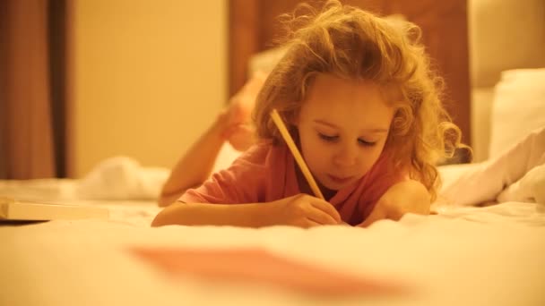 小さな女の子が何かを描いたり 書いたりする — ストック動画