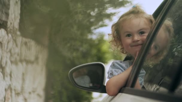 Χαμογελώντας Κοριτσάκι Κοιτάζοντας Έξω Από Παράθυρο Του Οδηγού Πλευρά — Αρχείο Βίντεο