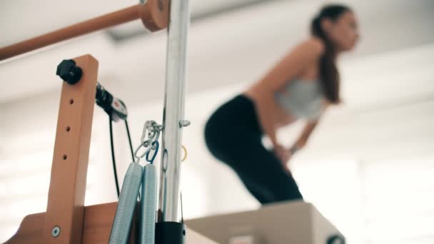 Woman Practices Pilates Reformer Equipment — Stock Video