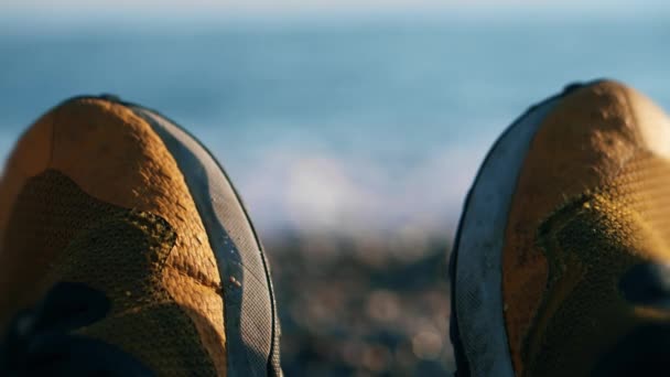 Παλιά Φθαρμένα Κίτρινα Αθλητικά Παπούτσια Κατά Της Θολής Γαλάζιας Θάλασσας — Αρχείο Βίντεο