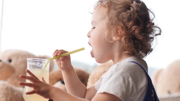 卷曲的小女孩用稻草喝柠檬水 — 图库视频影像