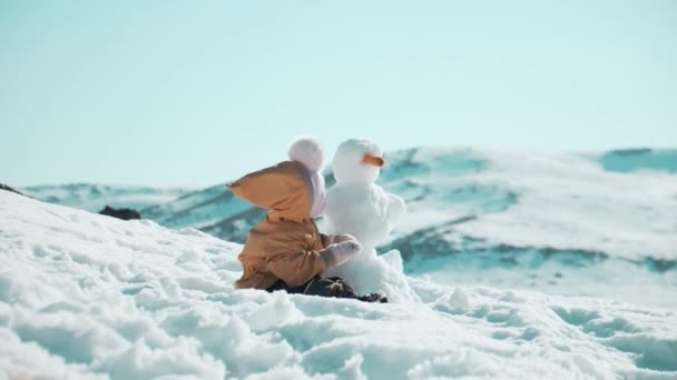 Усміхнена Дитина Біля Сніговика Горах — стокове відео