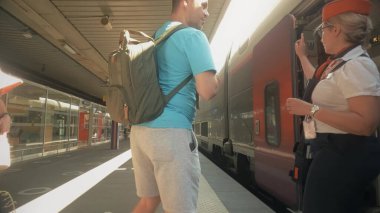 GRENOBLE, FRANCE - JUNE 9, 2023. Passenger boards high speed TGV clipart