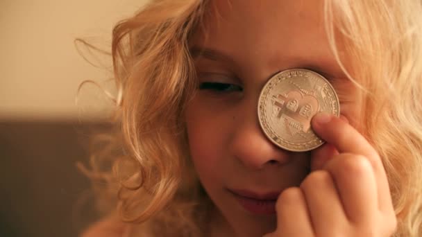 美しい金髪の少女はビットコインで遊びます — ストック動画