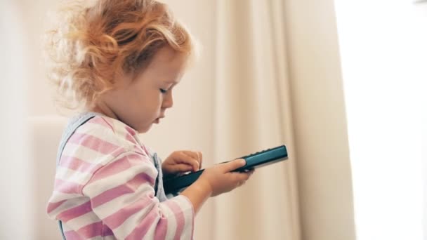 Little Girl Watches Uses Remote — Stock Video