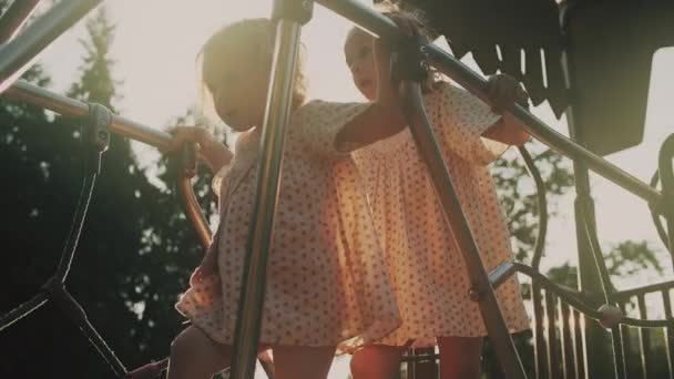 Kleine Zusjes Gelijkaardige Jurken Lopen Een Zonnige Speelplaats — Stockvideo