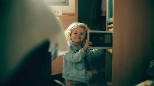 Little girl plays with a safe box