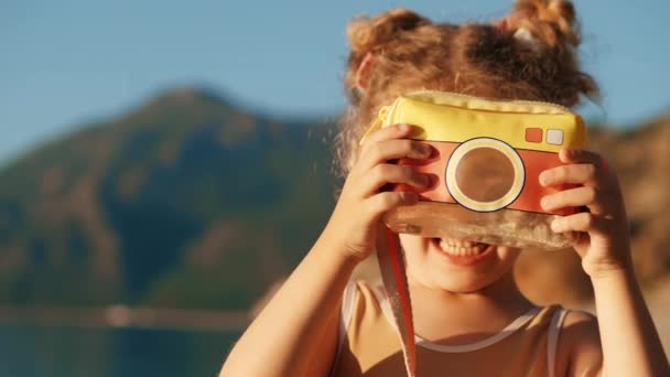 Glimlachend Meisje Maakt Foto Met Een Speelgoed Camera — Stockvideo
