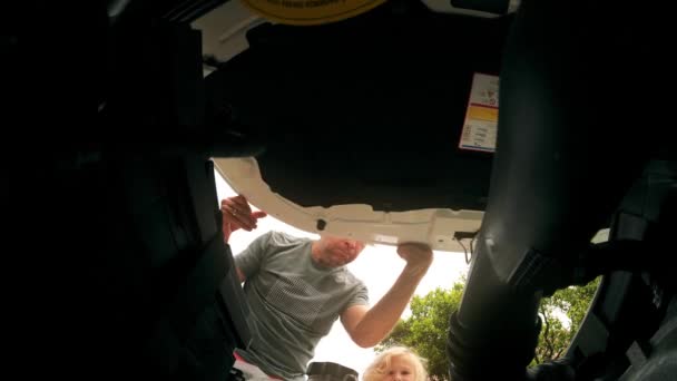 有趣的是 忧心忡忡的男人打开了他破车的车篷 — 图库视频影像