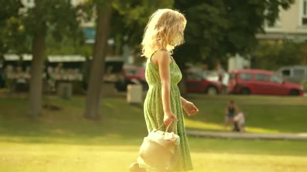 Mała Blondynka Zielonej Sukience Spaceruje Zielonym Trawniku — Wideo stockowe