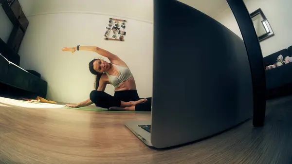 Flexible woman attends an online yoga class