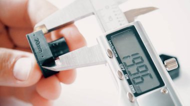 Measuring 3D printed sample with an electronic caliper clipart