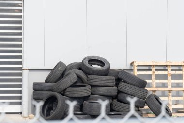 Geri dönüşümlü lastik yığını tel örgülerin arkasında.