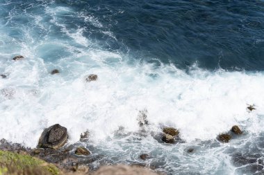 Okyanus kıyısındaki kayalar bulutlarla kaplı.
