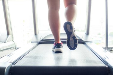 Sağlık ve kilo sorunları olan kadınlar spor salonunda koşu bandında egzersiz yapıyorlar. Sağlıklı ve egzersiz etkinliği kavramı.