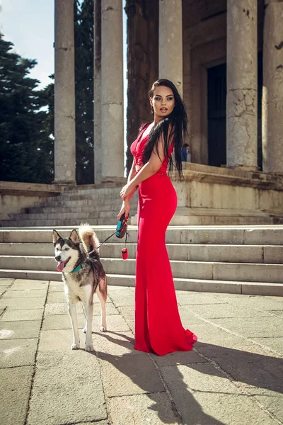 Красивая Молодая Женщина Длинном Красном Платье Наслаждается Прогулкой Собакой — стоковое фото