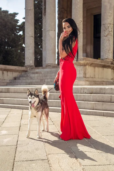 Gyönyörű Fiatal Hosszú Piros Ruhában Élvezi Sétát Kutyájával — Stock Fotó