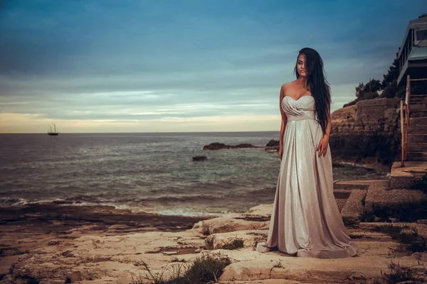 아름다운 머리의 여자가 드레스를 바다를 바라보는 즐긴다 — 스톡 사진