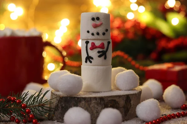Funny marshmallow snowman against Christmas festive decorations. Selective focus. Christmas or New Year greeting card.