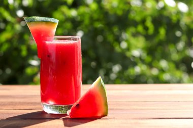 Fotokopi alanı olan yemyeşil yapraklara karşı karpuz kokteyli. Yaz ferahlatıcı içecekler, açık havada. Seçici odak.